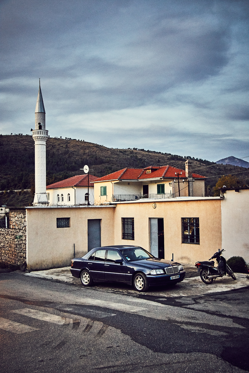 Vor einer Moschee parkt ein Auto und ein Roller